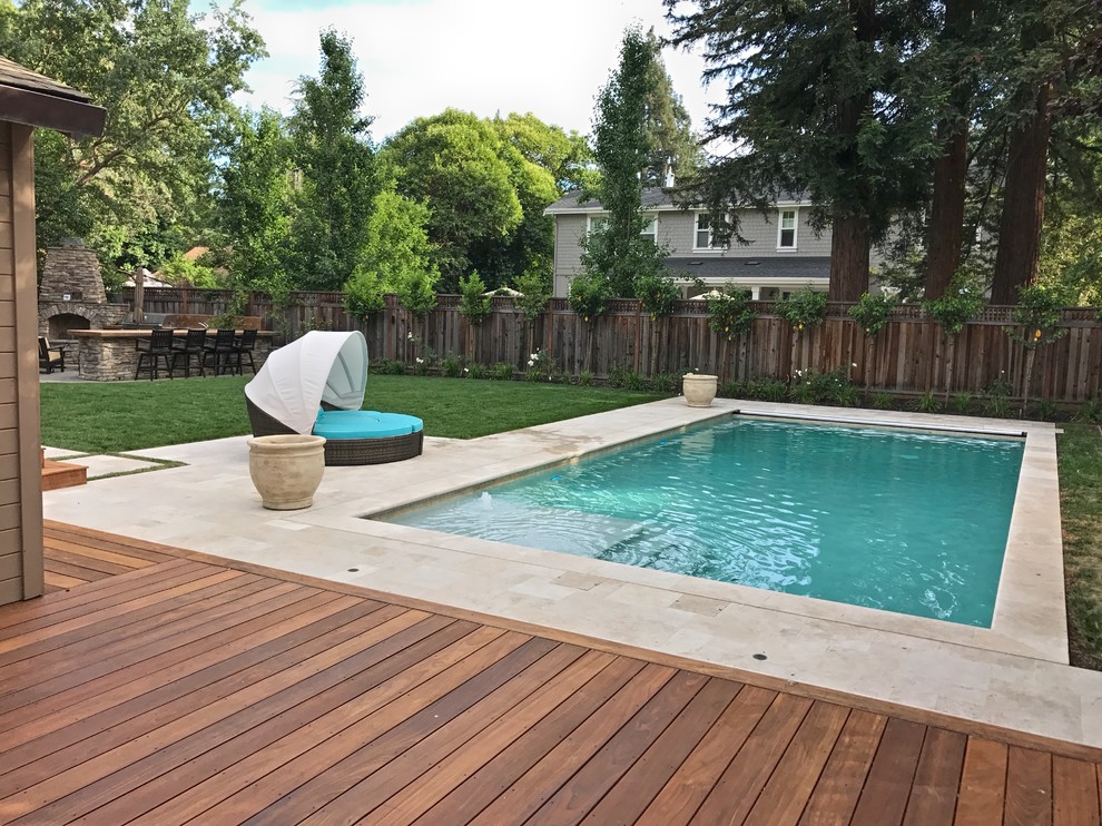 Diseño de piscina alargada moderna grande rectangular en patio trasero con suelo de hormigón estampado
