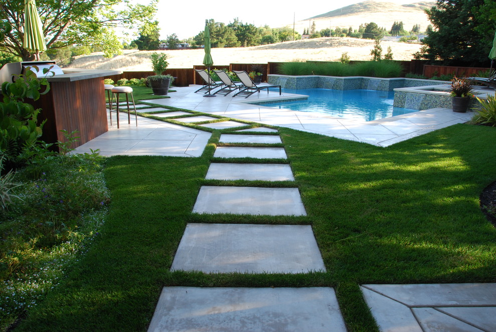 Diseño de piscinas y jacuzzis minimalistas, grandes, a medida, en patio trasero, con losas de hormigón