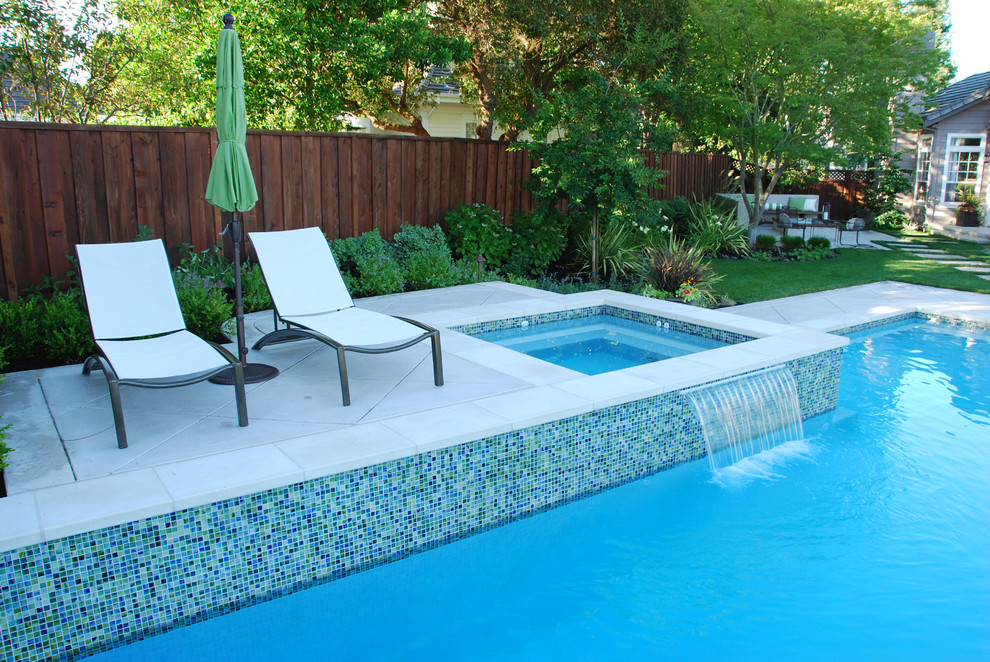 Modelo de piscinas y jacuzzis minimalistas grandes a medida en patio trasero con losas de hormigón