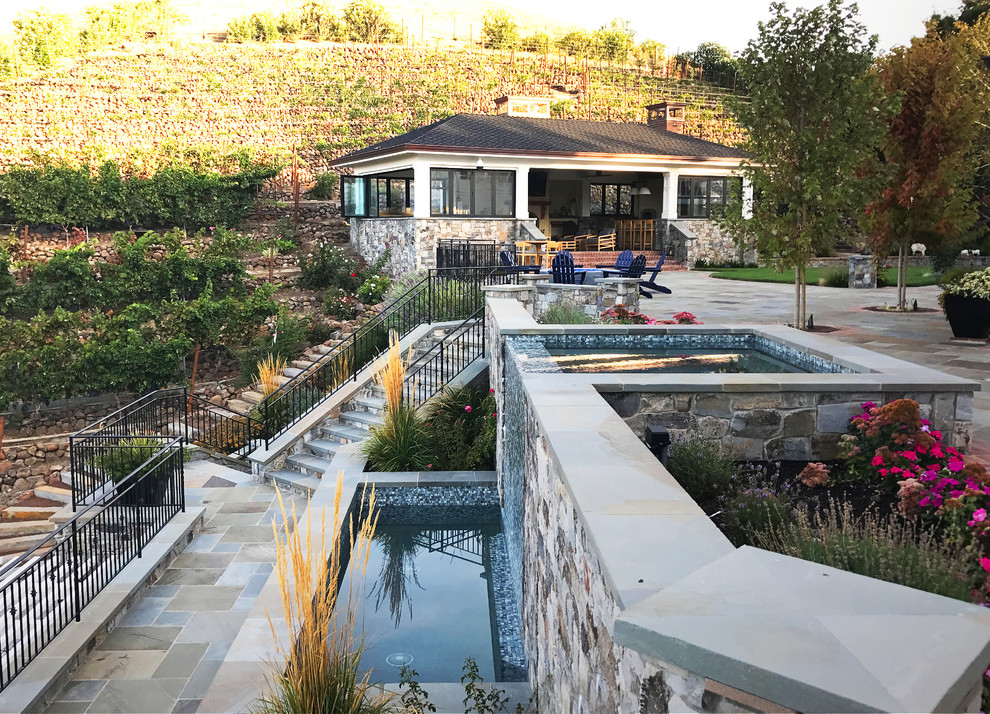 Ispirazione per una grande piscina a sfioro infinito minimalista rettangolare dietro casa con fontane e pavimentazioni in cemento