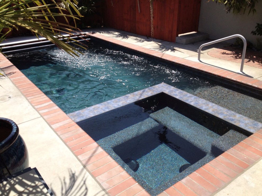 Foto de piscinas y jacuzzis alargados clásicos pequeños rectangulares en patio trasero con losas de hormigón