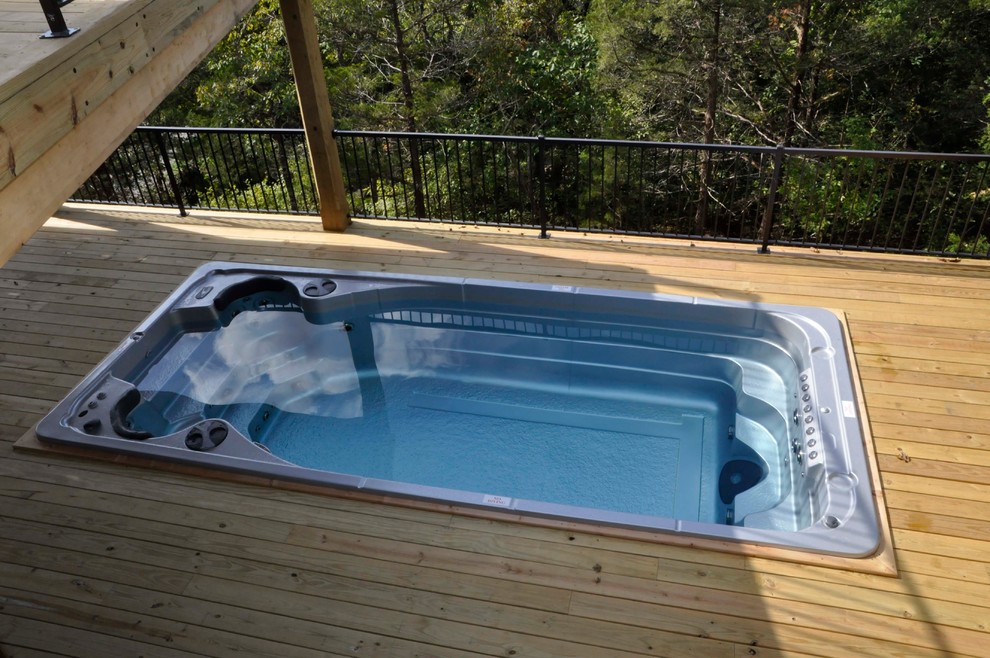 Ejemplo de piscina con fuente rural pequeña rectangular en patio trasero con entablado