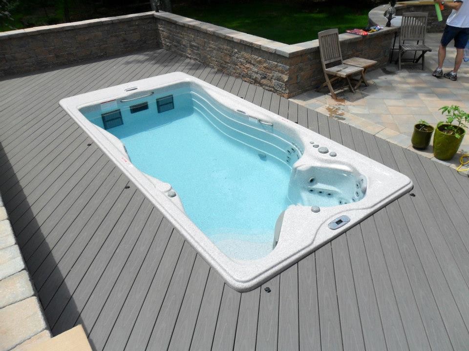 Ejemplo de piscinas y jacuzzis alargados clásicos grandes rectangulares en patio trasero con entablado