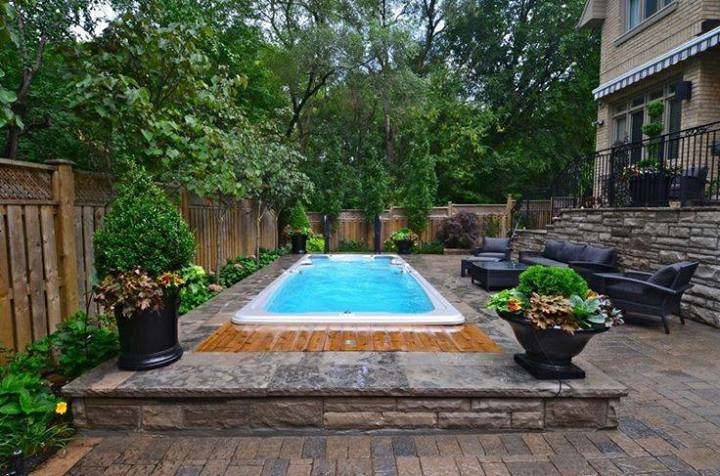 Diseño de piscinas y jacuzzis alargados clásicos grandes rectangulares en patio trasero con entablado