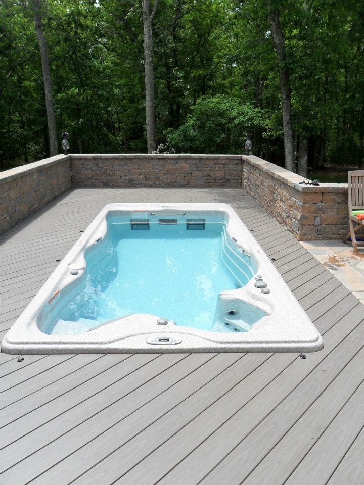 Modelo de piscinas y jacuzzis alargados tradicionales grandes rectangulares en patio trasero con entablado