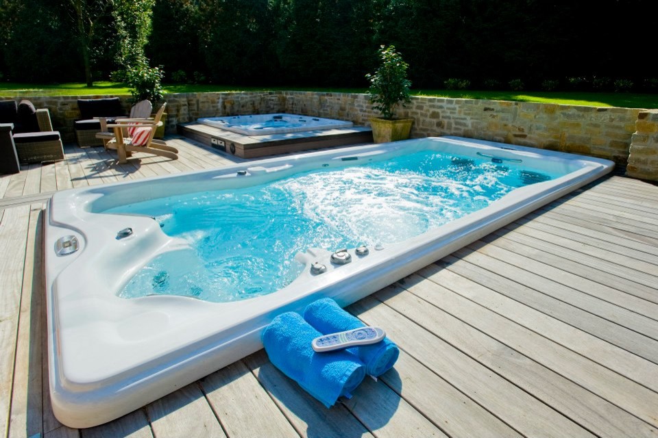 Esempio di una grande piscina fuori terra tradizionale rettangolare dietro casa con una vasca idromassaggio e pedane