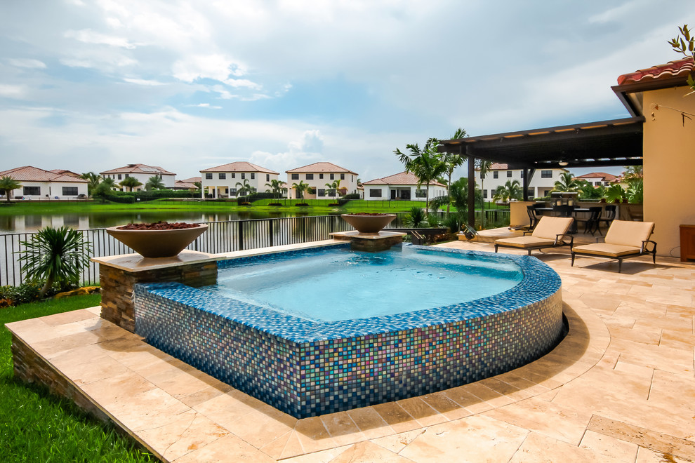 Ejemplo de piscinas y jacuzzis elevados minimalistas pequeños a medida en patio trasero con adoquines de piedra natural