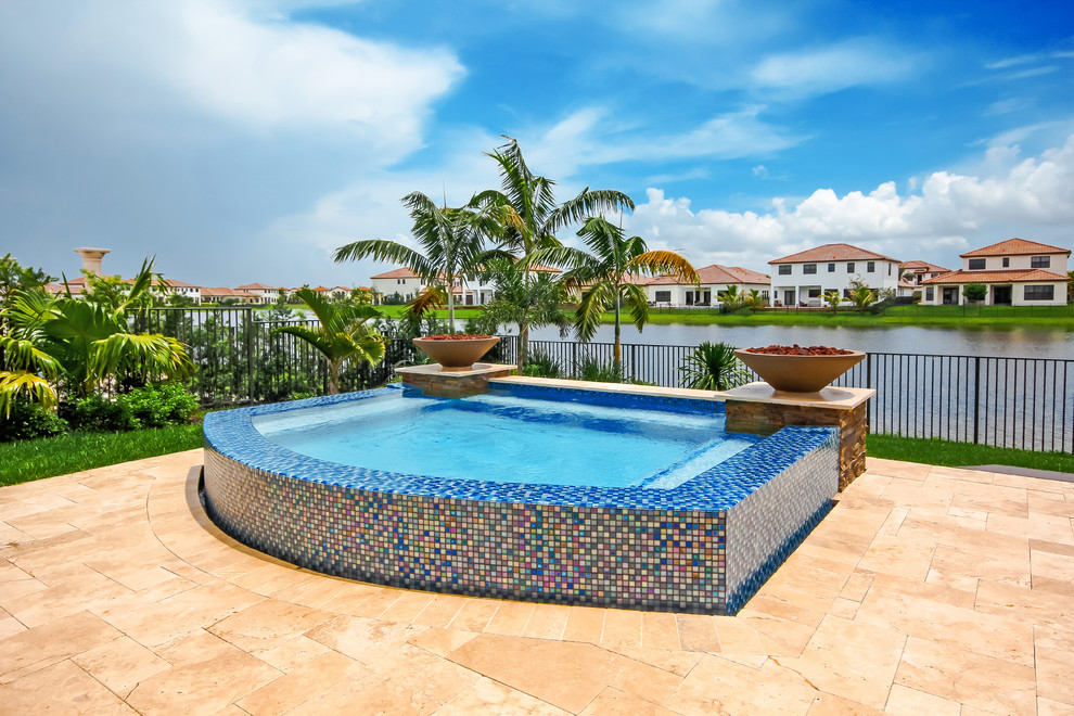 Esempio di una piccola piscina fuori terra minimalista personalizzata dietro casa con una vasca idromassaggio e pavimentazioni in pietra naturale