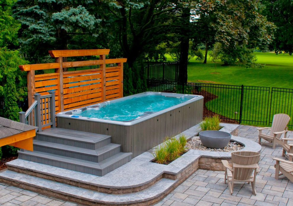 Ejemplo de piscina con fuente de tamaño medio en patio trasero con entablado