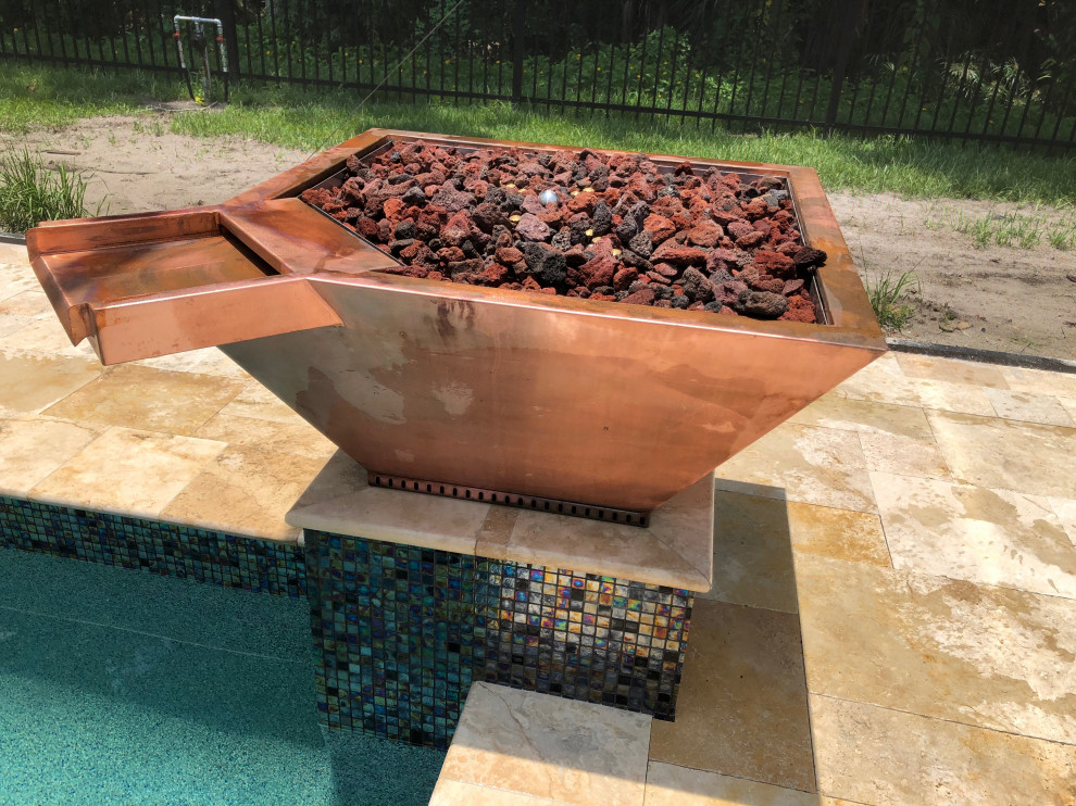 Cette photo montre une grande piscine arrière tendance rectangle avec un bain bouillonnant et des pavés en pierre naturelle.