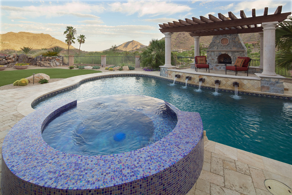 Design ideas for a large mediterranean back custom shaped natural swimming pool in Phoenix with a pool house and natural stone paving.