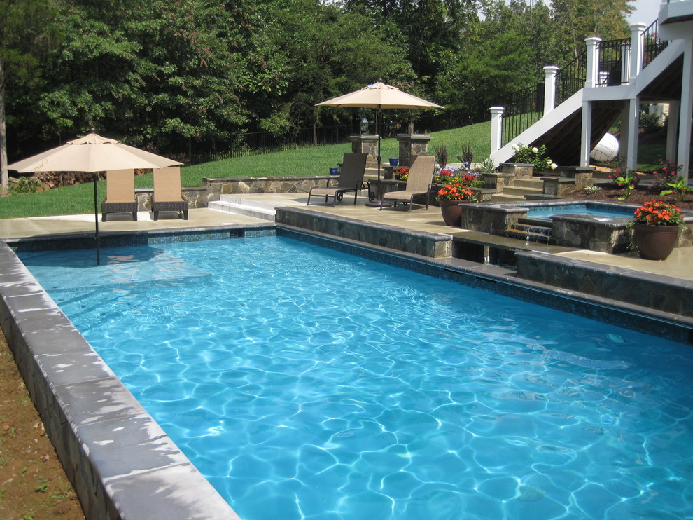 Idee per una piscina naturale classica rettangolare di medie dimensioni e dietro casa con lastre di cemento e una vasca idromassaggio