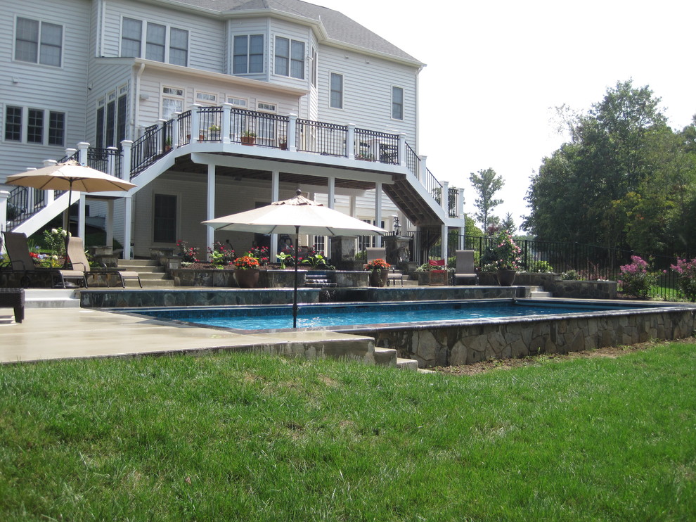 Ejemplo de piscinas y jacuzzis naturales tradicionales de tamaño medio rectangulares en patio trasero con losas de hormigón