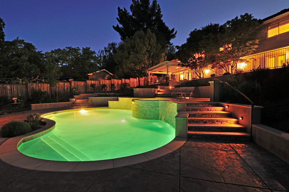 Стильный дизайн: естественный бассейн произвольной формы, среднего размера на заднем дворе в классическом стиле с фонтаном и покрытием из декоративного бетона - последний тренд