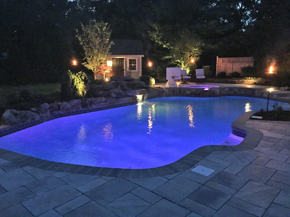 Großer Klassischer Schwimmteich hinter dem Haus in individueller Form mit Wasserspiel und Natursteinplatten in New York