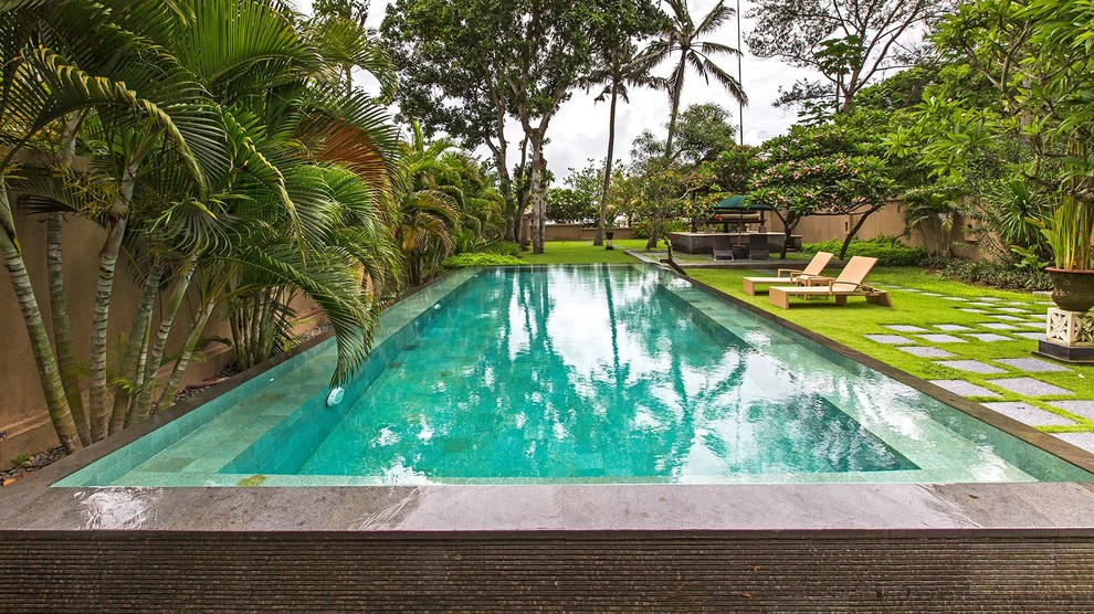 Foto di una piscina naturale etnica rettangolare di medie dimensioni e in cortile con una dépendance a bordo piscina e piastrelle