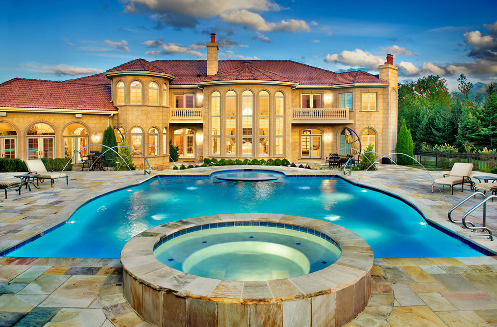 Immagine di una grande piscina monocorsia classica personalizzata dietro casa con una vasca idromassaggio e piastrelle