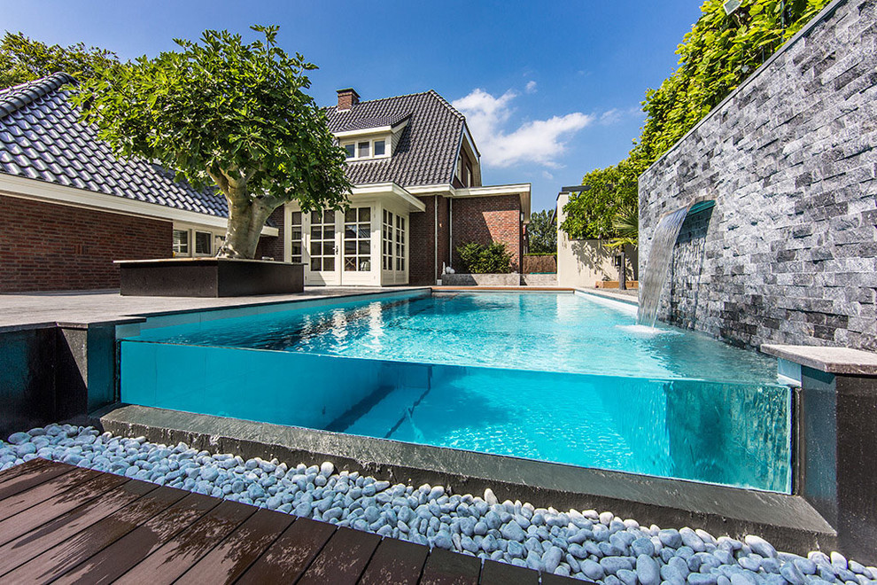 Immagine di un'ampia piscina coperta fuori terra moderna rettangolare con una dépendance a bordo piscina e piastrelle