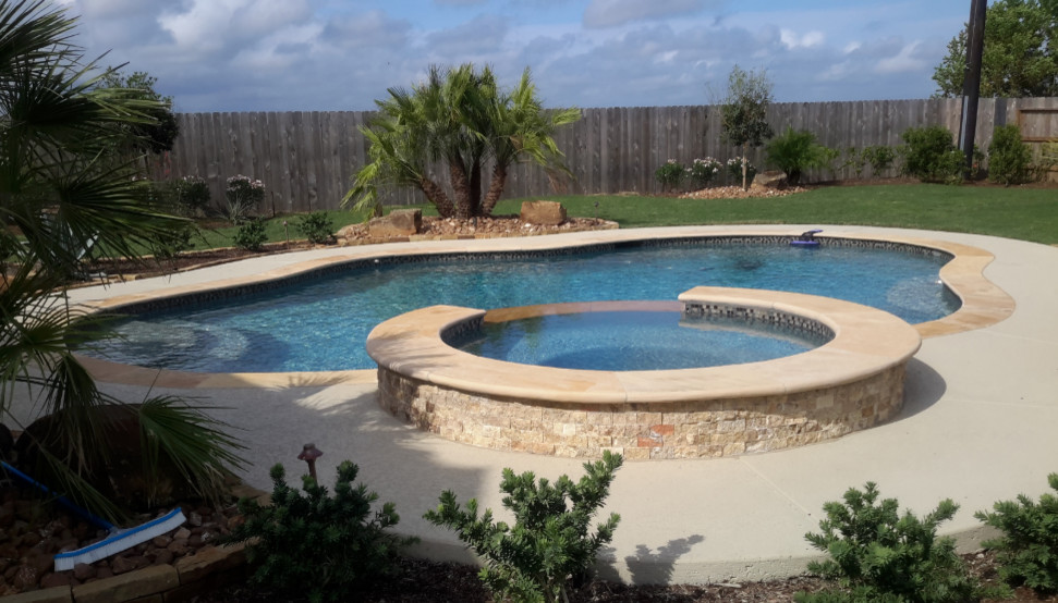 Идея дизайна: бассейн среднего размера, произвольной формы на заднем дворе в стиле неоклассика (современная классика) с джакузи и покрытием из бетонных плит