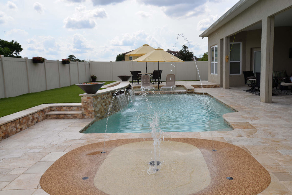 Exempel på en mellanstor exotisk njurformad pool på baksidan av huset, med naturstensplattor