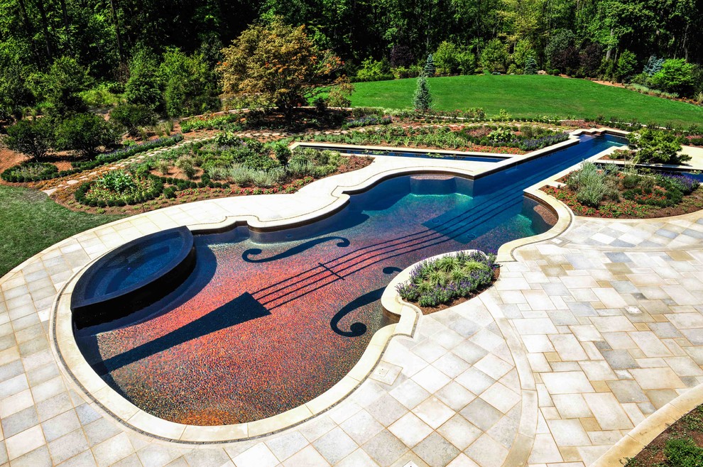 На фото: бассейн среднего размера, произвольной формы на заднем дворе в стиле фьюжн с джакузи с