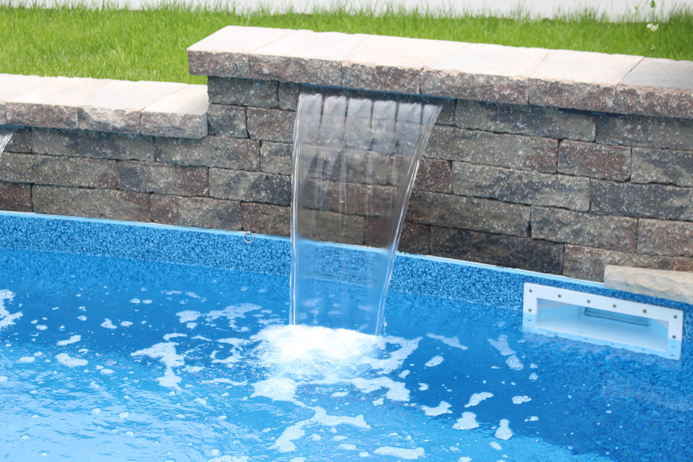 Пример оригинального дизайна: маленький бассейн произвольной формы на заднем дворе в стиле неоклассика (современная классика) с фонтаном и мощением тротуарной плиткой для на участке и в саду