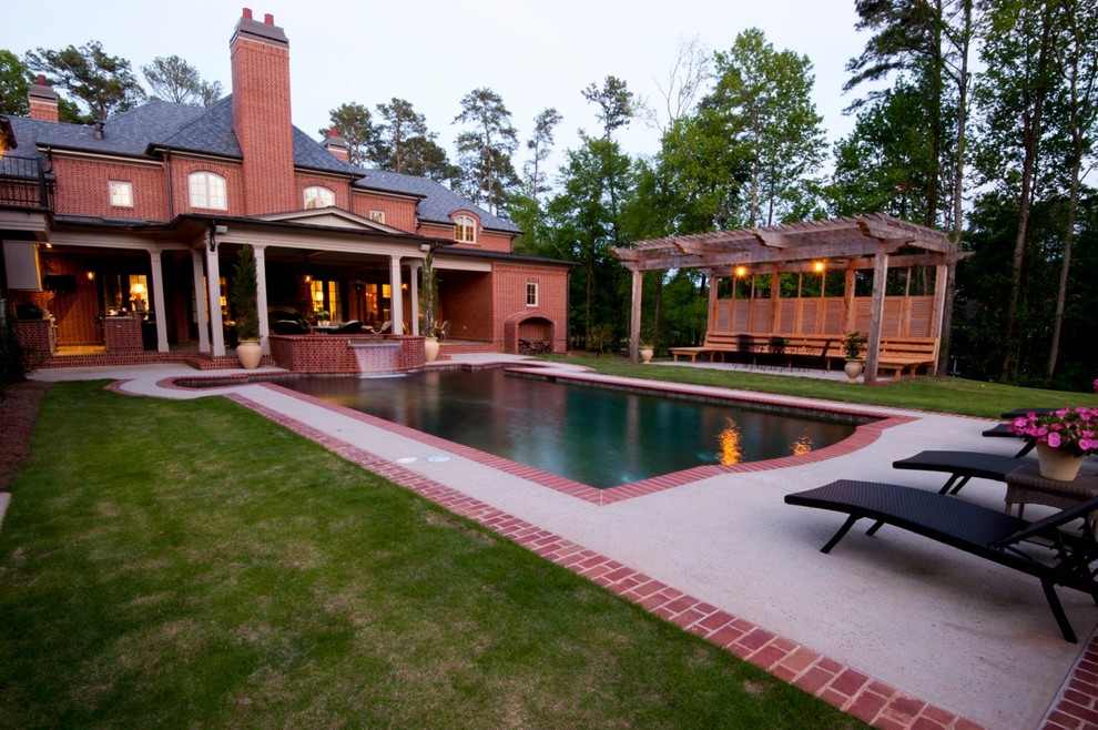 Diseño de piscinas y jacuzzis naturales tradicionales grandes rectangulares en patio trasero con adoquines de ladrillo