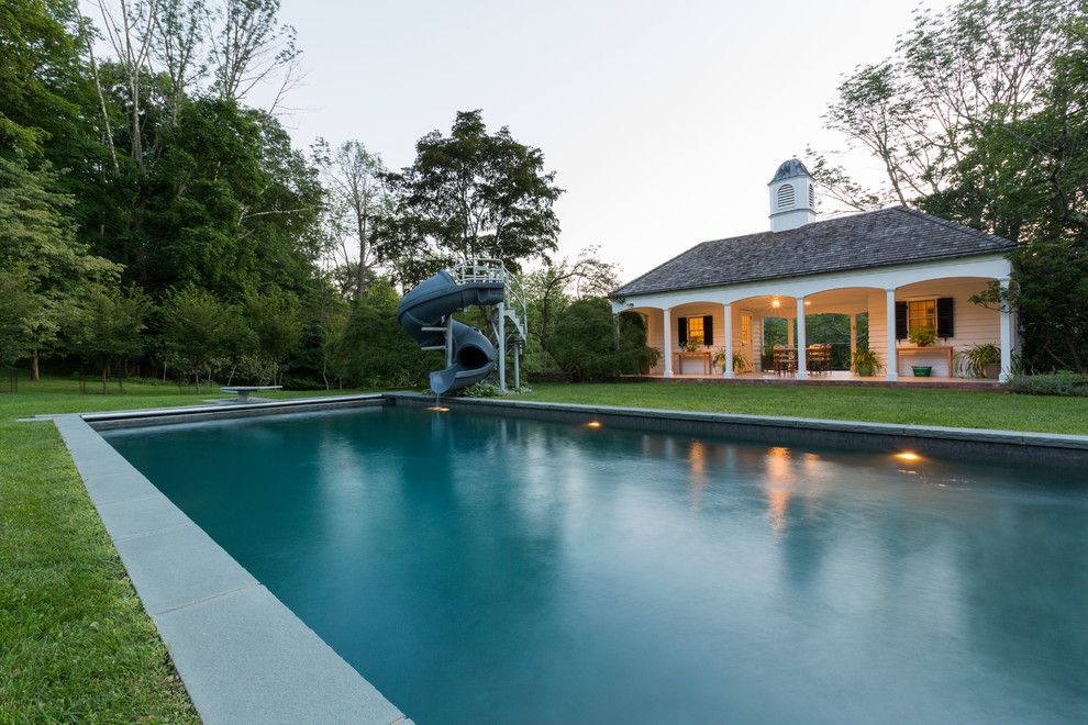 Foto di una grande piscina monocorsia minimal rettangolare dietro casa con una dépendance a bordo piscina e pavimentazioni in cemento