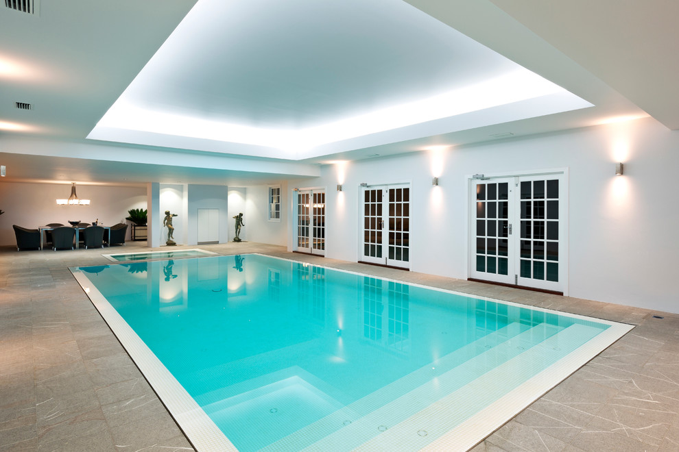 Пример оригинального дизайна: большой прямоугольный бассейн в доме в современном стиле с покрытием из каменной брусчатки и домиком у бассейна