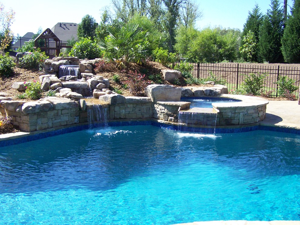 Example of a huge island style backyard natural pool design in Atlanta