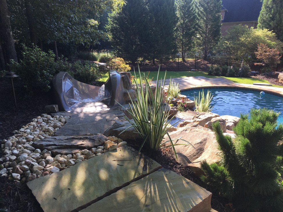 Inspiration for a huge tropical backyard custom-shaped natural water slide remodel in Atlanta