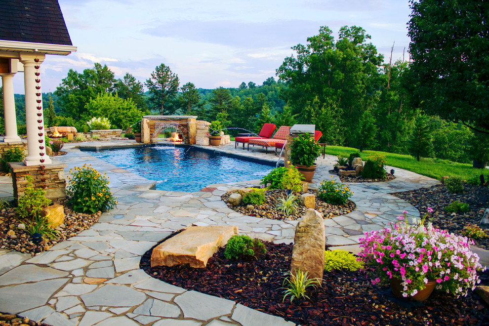 Esempio di una piscina naturale eclettica rettangolare dietro casa con fontane e pavimentazioni in pietra naturale
