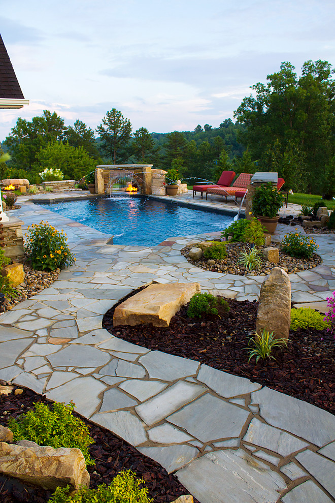 Diseño de piscina con fuente natural ecléctica rectangular en patio trasero con adoquines de piedra natural