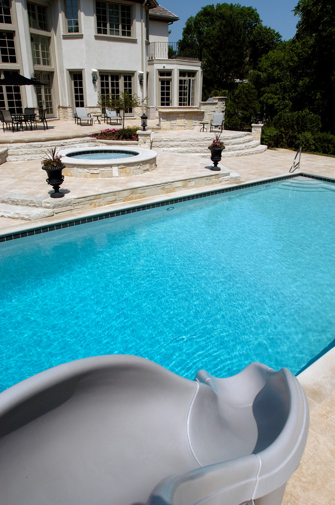 Esempio di una piscina monocorsia chic rettangolare di medie dimensioni e dietro casa con una vasca idromassaggio e pavimentazioni in pietra naturale
