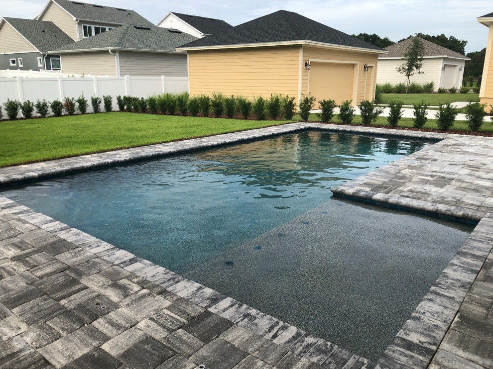 Inspiration for a medium sized modern back rectangular swimming pool in Orlando with concrete paving.