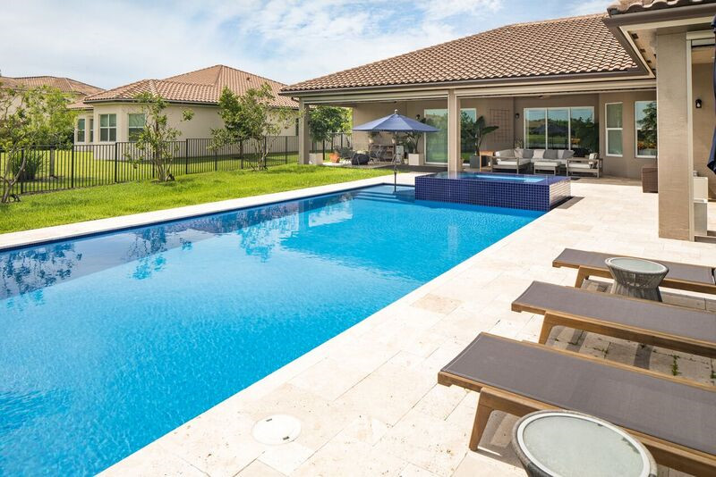 Idee per una grande piscina monocorsia moderna rettangolare dietro casa con pavimentazioni in pietra naturale