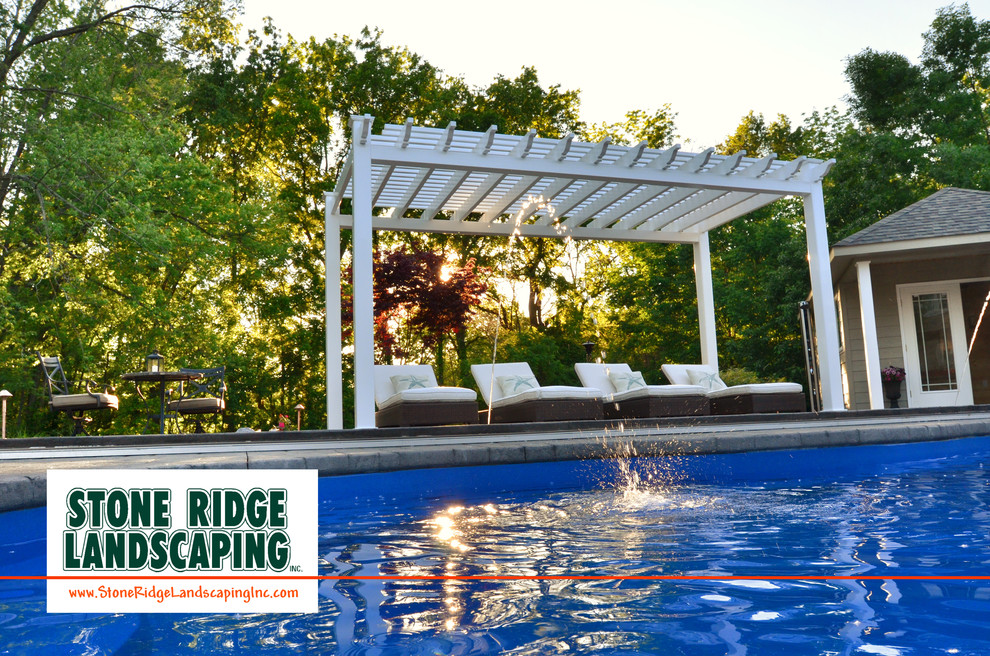 Идея дизайна: большой бассейн произвольной формы на заднем дворе в современном стиле с водной горкой и покрытием из декоративного бетона