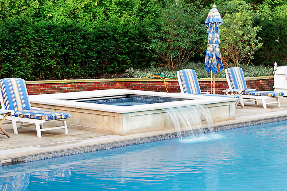 Immagine di una piscina monocorsia chic rettangolare di medie dimensioni e dietro casa con una vasca idromassaggio e piastrelle