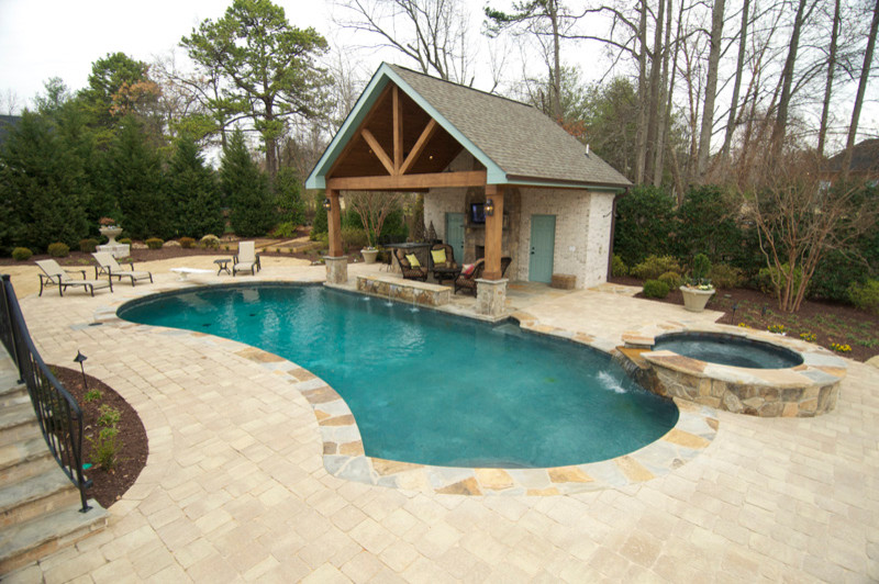 Mittelgroßer Uriger Pool hinter dem Haus in individueller Form mit Natursteinplatten in Sonstige