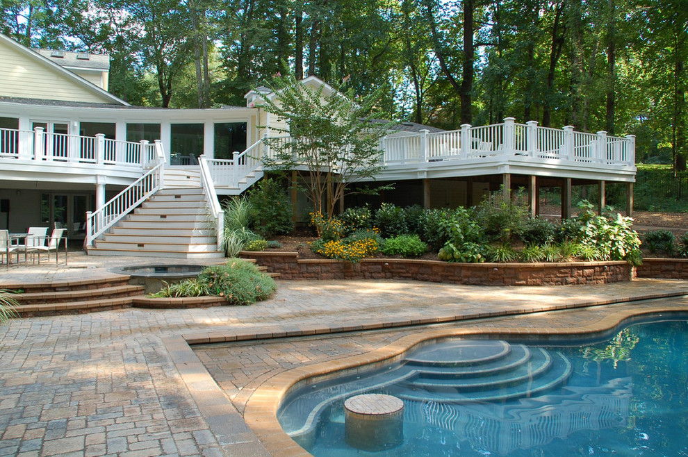 Foto di una grande piscina monocorsia moderna personalizzata dietro casa con pavimentazioni in pietra naturale