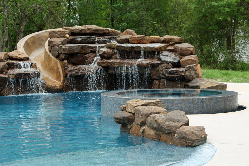 Großer Klassischer Schwimmteich hinter dem Haus in individueller Form mit Wasserrutsche und Natursteinplatten in Houston