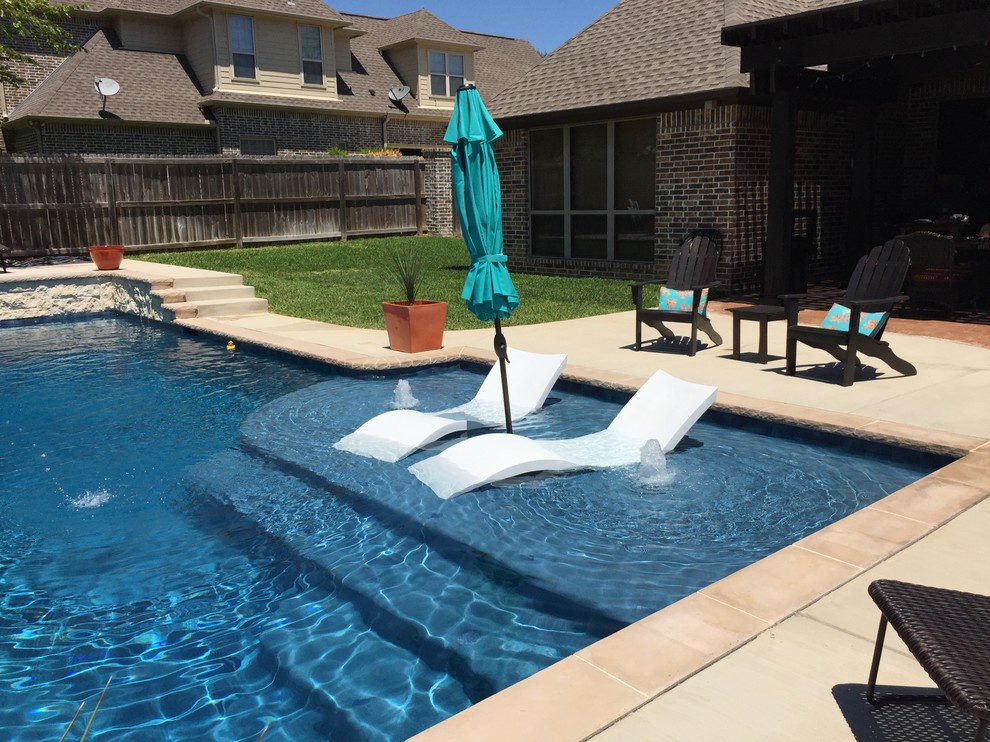 Photo of a medium sized classic back rectangular lengths swimming pool in Austin with a water feature and concrete slabs.