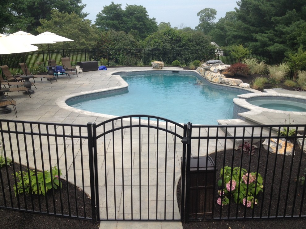 Imagen de piscinas y jacuzzis clásicos grandes a medida en patio trasero con adoquines de hormigón