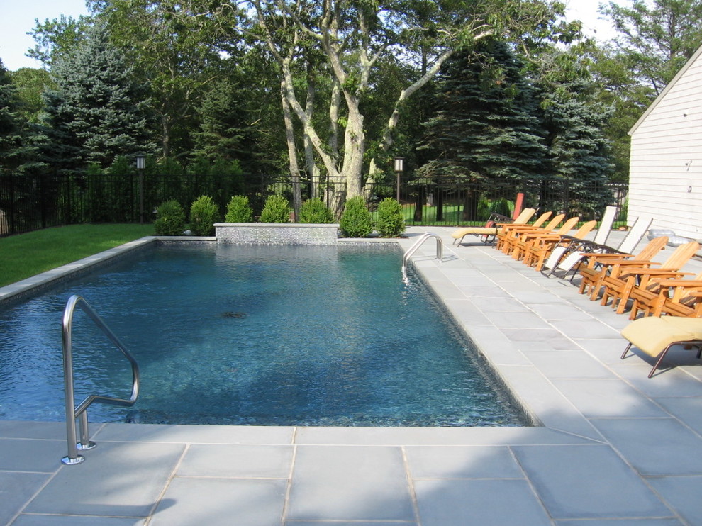 Modelo de piscina con fuente clásica extra grande rectangular en patio trasero con adoquines de piedra natural