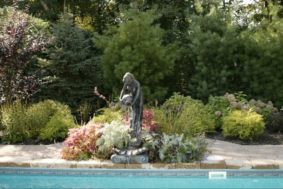 Inspiration for a mid-sized timeless backyard concrete paver and rectangular natural pool fountain remodel in New York