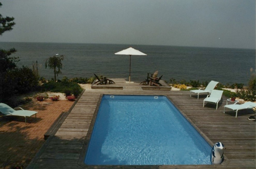 Immagine di una piscina naturale chic personalizzata di medie dimensioni e dietro casa con una vasca idromassaggio e pavimentazioni in pietra naturale
