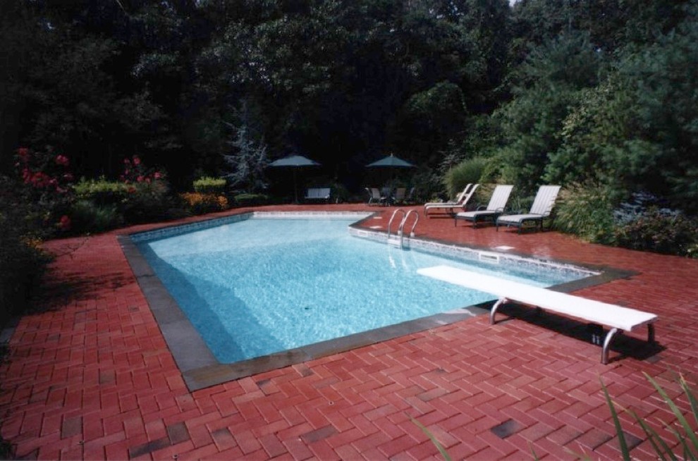 Klassischer Pool hinter dem Haus in individueller Form mit Natursteinplatten in New York