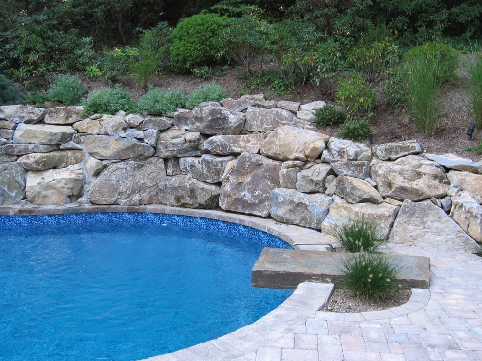 Example of a large classic backyard concrete paver and custom-shaped pool fountain design in New York