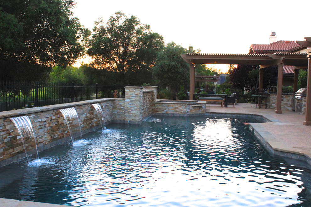 Ejemplo de piscina con fuente contemporánea de tamaño medio a medida en patio trasero con losas de hormigón