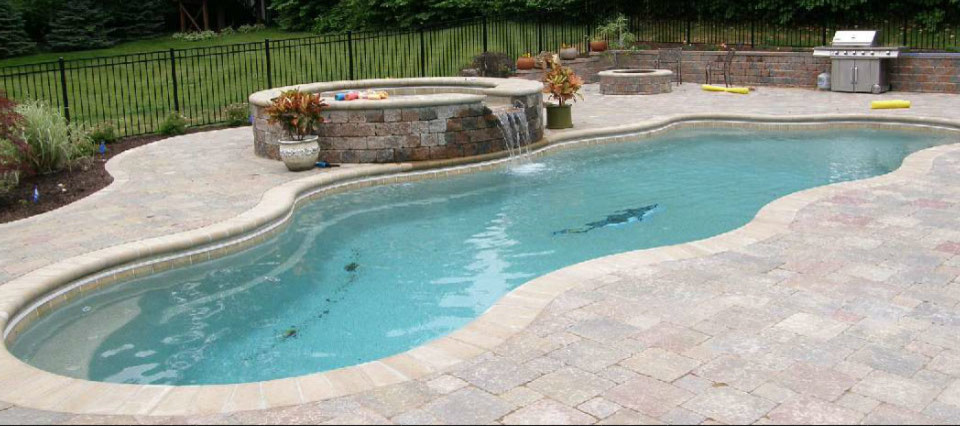 Imagen de piscina con fuente natural rural de tamaño medio a medida en patio trasero con adoquines de piedra natural